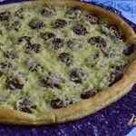 Закусочная лепешка и копчеными колбасками и луком