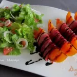 Летняя закуска с кусочками дыни и сухой ветчиной