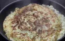 Перевернуть омлет, посыпать сыром и перцем