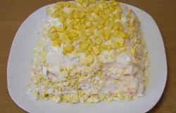 Салат снаружи смазать майонезом, посыпать кукурузой и яйцом