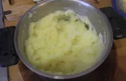 С картофеля слить воду, добавить молоко и сливочное масло. Тщательно перемешать, чтобы не образовалось комочков