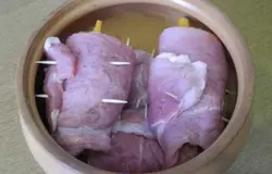 Сложить рулетики из свинины в горшочек для запекания