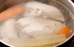 Куриные грудки залейте чистой водой, чтобы она только покрыла мясо, добавьте очищенные овощи, посолите.  Доведите до кипения, снимите пену и варите на среднем огне еще 10-15 минут. Слишком долгая варка сделает мясо слишком сухим и невкусным, так что следите.  Отвар сохраните.