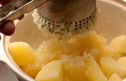 Слейте воду и быстро, пока картофель горячий, разомните ее толкушкой или пропустите через специальный пресс. 