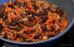 Разогреть масло и обжарить в нём цельную очищенную луковицу (у меня чеснок). Когда она станет золотистого цвета, а масло окрасится, убираем её. Кладём баранину и обжариваем. Добавляем мякоть помидоров, нарезанные лук и морковь, продолжаем жарить. Солим, перчим.
