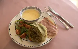 Я подавал с салатом из рукколы с томатами и сырокопчёной свининой.  Соус подавать удобнее в маленькой миске, туда удобно макать лепестки артишоков.