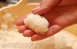 Гункан-суши - это своеобразная "ёмкость" из риса и нори, идеально подходящая для наполнения измельчённой начинкой. Чтобы приготовить гункан, влажной ладонью возьмите немного риса и сформируйте из него продолговатый комочек. 