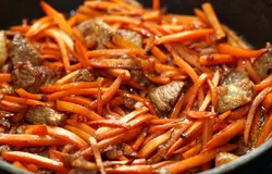 Когда мясо немного обжарится (7-8 минут), добавляйте морковь. Готовьте еще 5 минут до мягкости моркови.