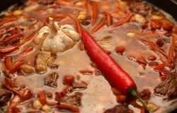 Налейте воды так, чтобы она покрывала мясо. Вставьте в середину целый чеснок, очищенный от верхней шелухи и корешков и острый перец.