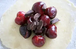 На сахар выкладываем черешню, немного, по 7-8 ягодок, а сверху присыпаем кусочками шоколада: