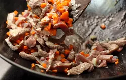 Добавьте морковь и мясо. Готовьте, помешивая, до тех пор, пока мясо не потеряет розовый оттенок.