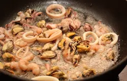 Выложить в сковороду морепродукты. Если вы используете замороженные (как я в данном случае), то их лучше заранее разморозить и слить жидкость.  Готовить буквально 1 минуту.