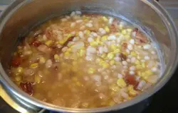 Обжаренный бекон и лук кладем в кастрюлю с вареной фасолью и провариваем вместе пару минут.