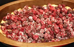 Испеченное тесто посыпаем молотым миндалем и выкладываем на него ягоды.
