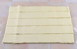 Тесто разморозить, развернуть, раскатывать не нужно. Порезать на полоски не менее 5-6 см шириной (у меня получилось 5 полосок).