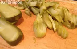 Маринованные огурцы нарезаем пластинами, а потом поперек соломкой. Если огурцы содержат жидкость, их надо слегка отжать перед добавлением в салат.