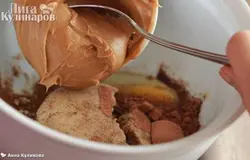 Если арахис у вас не жареный, обжарьте его, помешивая, на сухой сковороде в течение 15 минут. Затем в блендере превратите его в муку, добавьте сахарную пудру и рафинированное масло. Взбейте.  В миску разбейте яйцо, добавьте коричневый сахар, какао, корицу и имбирь и выложите арахисовую пасту