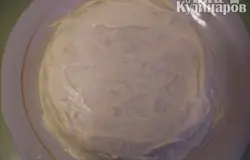 Через 3 часа достать из холодильника салат, накрыть его блюдом и перевернуть. Снять пленку, смазать верх и бока майонезом.