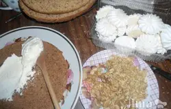 Остывшие коржи разрезать вдоль на два. Для крема взбиваем сливки с сахаром. Грецкие орехи нарезаем.