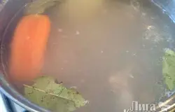 Солим, закидываем 1/2 шт. моркови и половинку репчатого лука, а также лавровые листики.  Варим бульон под крышкой на маленьком огне 1,5-2 часа