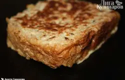Ставим сковороду на средний огонь. Смазываем сливочным маслом. Каждый ломтик хлеба окунаем в яичную смесь и обжариваем с двух сторон до корочки, по 2-4 минуты