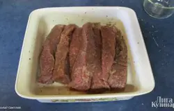 Солим, причем руками втираем соль во всю поверхность мяса. Затем приправляем перцем и кориандром. Отправляем мариноваться в холодильник на 12-24 часа.