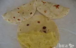 Остывшие лепешки раскладываем на столе и на них укладываем на одну сторону начинку: картофельную, прикрываем второй частью.