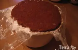 Взять миску для взбивания (2,5 л). Бисквит разрезать вдоль. Вырезать по диаметру миски основание. Остальной бисквит поломать на мелкие кусочки. Взбить крем. Миску простелить пленкой. Каждый кусочек бисквита обмакивать в крем и складывать в миску (можно добавить дробленые орехи, ягоды, джем). Сверху накрыть основанием. Завернуть края пленки и поставить в холодильник на 5-6 часов.