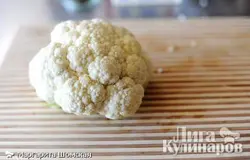 Разрежьте качан цветной капусты на мелкие кусочки, удаляя стебли и листья. Заполните большую кастрюлю количеством воды достаточным, чтобы покрыть цветную капусту. Доведите воду до кипения. Положите цветную капусту в кипящую воду и варите до размягчения, 2-5 минут. Слейте приготовленную цветную капусту и поставьте охлаждаться.