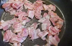 Нарезанный бекон кладем на сухую сковороду и нагреваем на медленном огне, пока не начнет вытекать жир. Увеличить огонь и обжаривать до золотистой корочки. Добавить лук и готовить еще около 3 минут до мягкости.