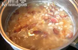 Добавить фасоль и бульон в кастрюлю и готовить на медленном огне, пока бульон не уварится на половину. Вместо консервированной фасоли можно использовать сухую, тогда перед приготовлением её нужно замочить в холодной воде на 4 часа.