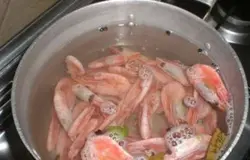 Нам нужны креветки для этого салата. Замороженные креветки разморозить при комнатной температуре. Сначала необходимо поставить на огонь кастрюлю с водой и посолить. После того как вода закипит, бросаем в нее креветки и будем варить минуты 3 на среднем огне.