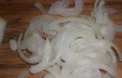 Теперь нужно приготовить заправку для салата. Для этого в неглубокой миске смешиваем горчицу, майонез и добавляем сок лимона. Лимонный сок нужно выдавить из половинки свежего лимона, используя соковыжималку или просто руками. Всё тщательно перемешать. Соус для нашего салата готов. Осталось нарезать все необходимые ингредиенты. Почистить репчатый лук и нарезать полукольцами.