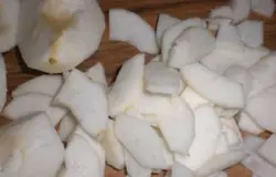 Открыть банку маслин, слить с них сок и разрезать на две части.Очистить от кожуры яблоки, удалить семена и нарезать некрупными дольками.