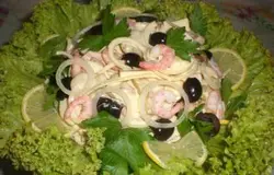 Красиво украсим вкусный салат перед подачей на стол. На блюдо разложим листья салата и на них сверху аккуратно выложим салат. Украсить зеленью, лимоном и подать на стол.