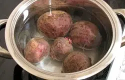 Для начала необходимо отварить все овощи. В одну кастрюлю сложите морковь с картофелем, в другую – свеклу. Залейте водой выше на два сантиметра и варите до готовности. Проверить можно готовность овощей, воспользовавшись вилкой или ножом.
