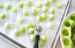 Для начала самостоятельно приготовьте лед для вкусного коктейля. В формы для льда своими руками налейте смесь чистого лимонного сока и простой воды (1 лимон к 1 л воды). Далее возьмите дыню и вымойте ее. Немного обсушите и затем разрежьте пополам. Удалите косточки и мякоть, оставляя только чистую твердую часть.