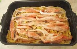 Нарезать полосками рыбу, уложить ее на картофель. Поперчить, а затем уложить слой лука. После этого сверху накрыть пирог тестом.