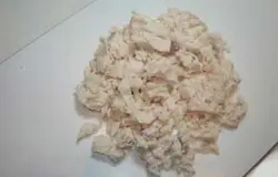 Отварите куриное мясо в кипящей воде, в небольшой кастрюле. Остудите. Готовое, чуть подсоленное куриное филе (грудинку), нарежьте на мелкие кусочки.