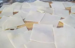 Пока мясо варится, делаем тесто, как для лапши. В миску всыпаем просеянную муку (половину нормы), вливаем разболтанные яйца, добавляем соль и воду (или же холодный бульон). Замешиваем крутое тесто, подсыпая остальную муку. В хорошо вымешанном тесте на разрезе не должно быть воздушных пузырьков. Готовое тесто заворачиваем в пищевую пленку или в чуть влажное полотенце и оставляем на полчаса. На столе, густо посыпанном мукой, раскатываем тесто, беря от целого куска часть, размером со среднее яблоко (остальное тесто, чтобы не заветривалось заворачиваем в пленку). Тесто раскатываем толщиной в 1,5-2 мм. Далее пласты теста режем на полосы, а затем – на ромбы, посыпаем густо мукой и пусть так лежат на столе до готовности мяса.