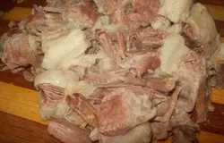Когда мясо сварится, вынимаем его при помощи шумовки, а также удаляем из бульона специи и овощи. Бульон процеживаем. Мясо отделяем от костей и нарезаем на небольшие кусочки.