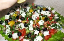 Сверху выложить кубики сыра и маслины (можно порезать пополам). Зелень мелко порубить и посыпать сверху. Полить салат сверху свежевыжатым лимонным соком.