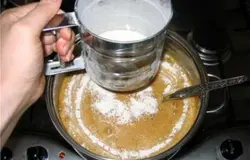 Снимаем кастрюлю с огня и постепенно вмешиваем муку, самый лучший вариант – это постепенно просеять ее. Тесто будет однородное, по консистенции напоминающее пластилин.