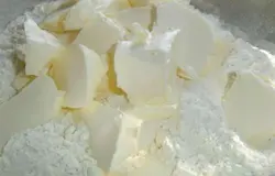 К просеянной муке добавляем сливочное масло, порезанное кусочками, хорошенько перетираем до образование крошки,