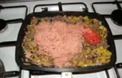 Добавляем тертую колбасу и помидоры к жареному картофелю и луку.