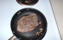 Разогреваем масло в сковороде, добавляем немного имбиря. Обжариваем мясо с каждой стороны по 3 минуты. Откладываем мясо в сторону. Смешиваем саке и соевый соус. Маринуйте говядину в смеси минут 20.