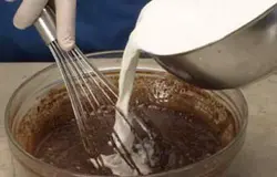 Смешайте порошок какао, затем добавьте толченые булочки (по Итальянскому рецепту это Amaretti) и ром. Нагрейте молоко отдельно и затем добавьте его к смеси, непрерывно помешивайте венчиком.