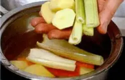 Картофель, лук и морковь очистить, нарезать крупными кусками. Положить морковь, петрушку и лук в кастрюлю с водой, довести до кипения Варить 15 мин. Добавить сельдерей и картофель. варить еще 20-25 мин. Шумовкой переложить картофель в миску.
