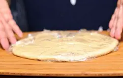 Взять тесто, разрезать на две части и выровнять кулаками. Опять же, накрыть тесто полиэтиленовой пленкой и дать постоять еще 10-15 минут.