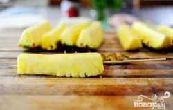 Насадите кусочки фрукта на деревянные шампуры.